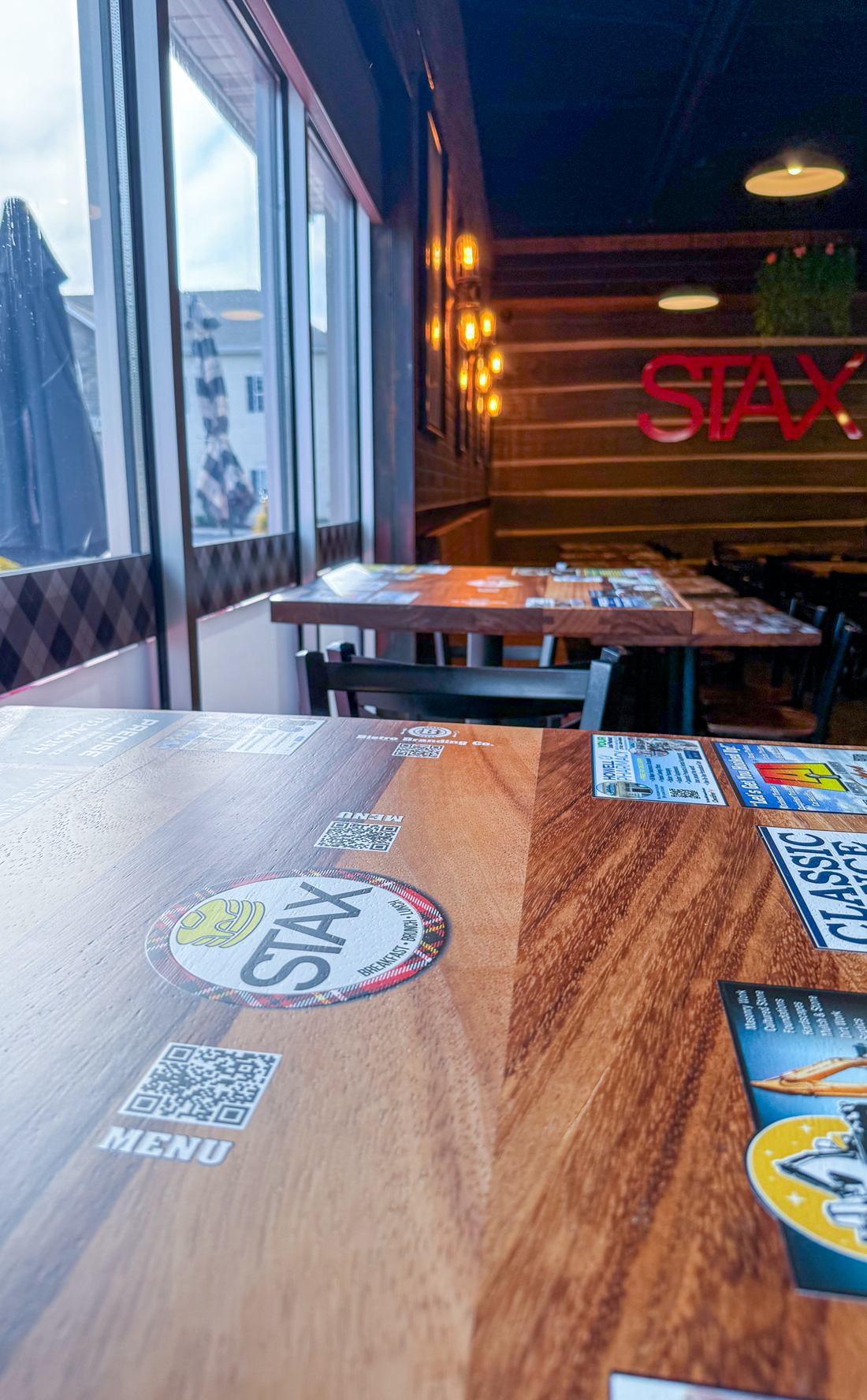 A restaurant logo and menu QR code printed directly into a hardwood tabletop